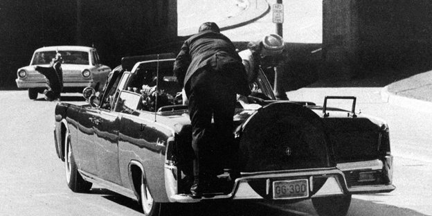 ADVANCE FOR USE SUNDAY, NOV. 17, 2013 AND THEREAFTER - FILE - In this Friday, Nov. 22, 1963 file photo, President John F. Kennedy slumps down in the back seat of the Presidential limousine as it speeds along Elm Street toward the Stemmons Freeway overpass in Dallas after being fatally shot. First lady Jacqueline Kennedy leans over the president as Secret Service agent Clint Hill pushes her back to her seat. "She's going to go flying off the back of the car," Hill thought as he tried to secure the first lady. (AP Photo/James W. "Ike" Altgens)
